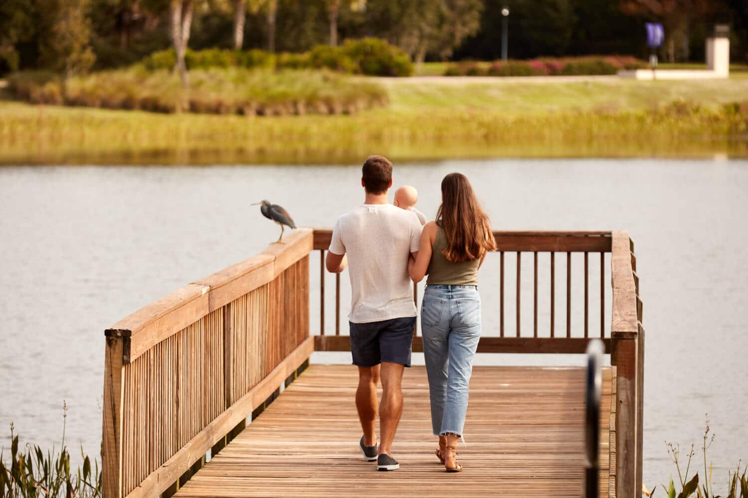 Two adults walking on a wooden dock with beautiful waterfront views at Ridley at Waterset in Apollo Beach, FL.