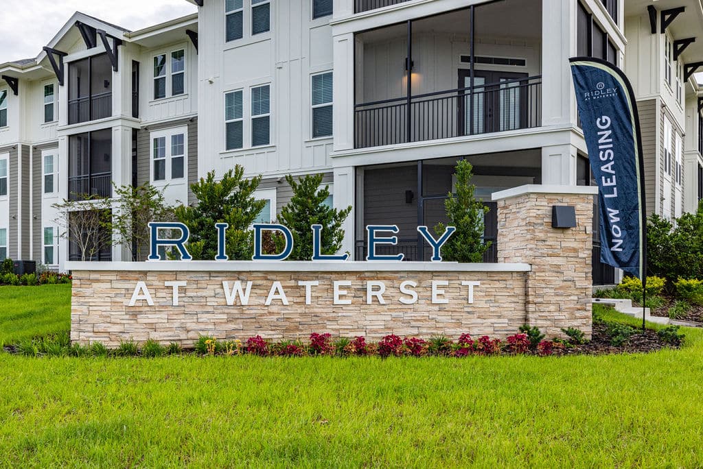A Ridley at Waterset sign and a Now Leasing banner in front of 3-story apartment buildings in Apollo Beach, FL