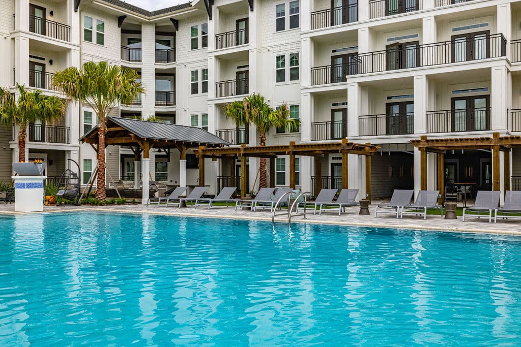 a refreshing swimming pool with a sundeck, lounge chairs, cabanas, and apartments with private balconies.
